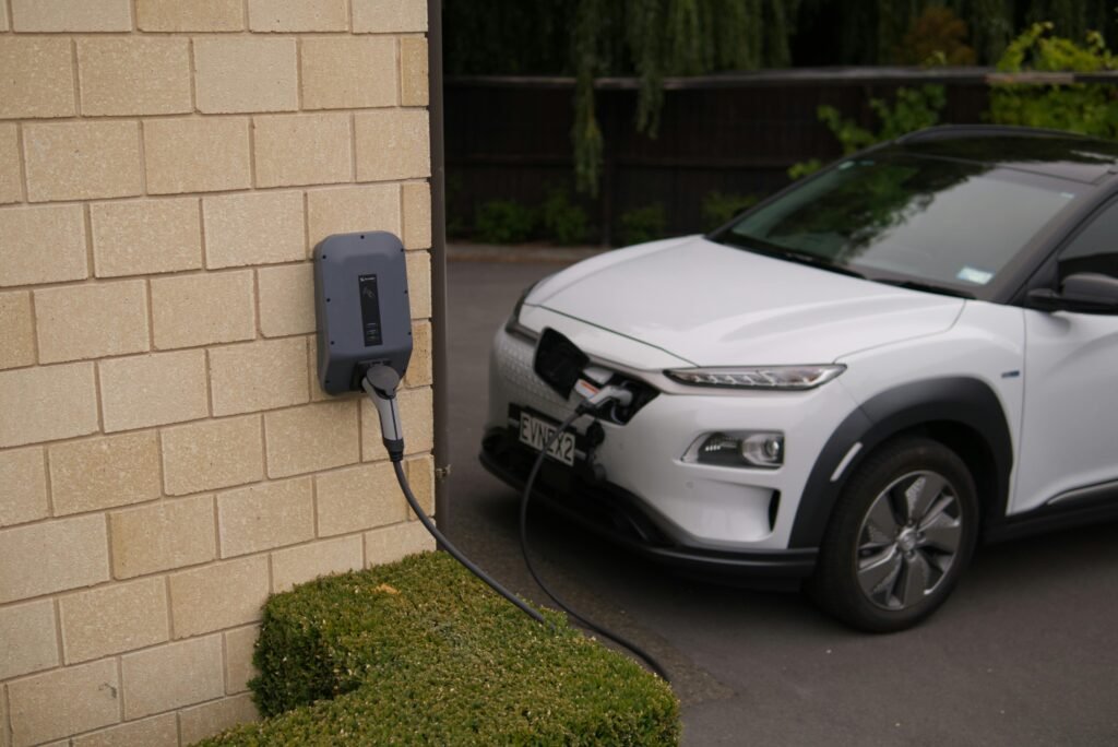 A white electric car charging at a station in Christchurch, New Zealand, showcasing modern eco-friendly transportation.